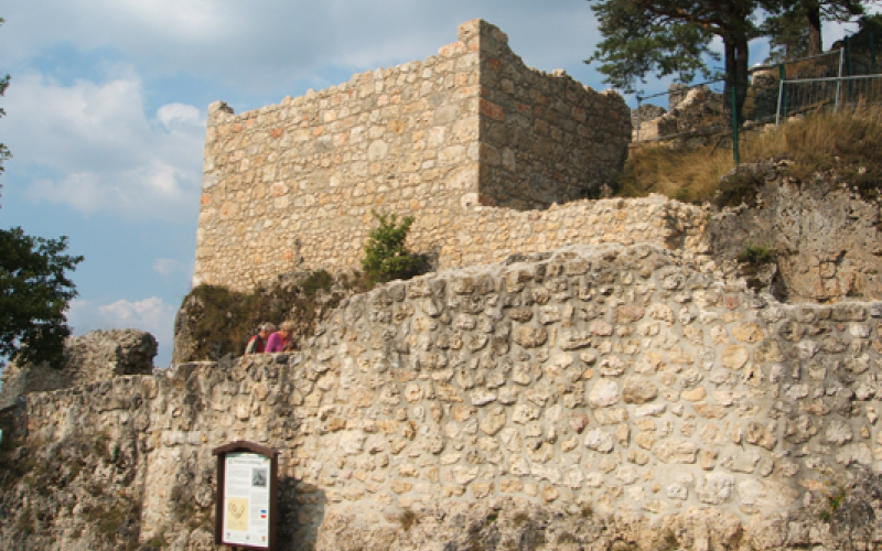 Sanierte Bruchsteinmauer der Burgruine Lichtenegg mit Informationstafel im Vordergrund